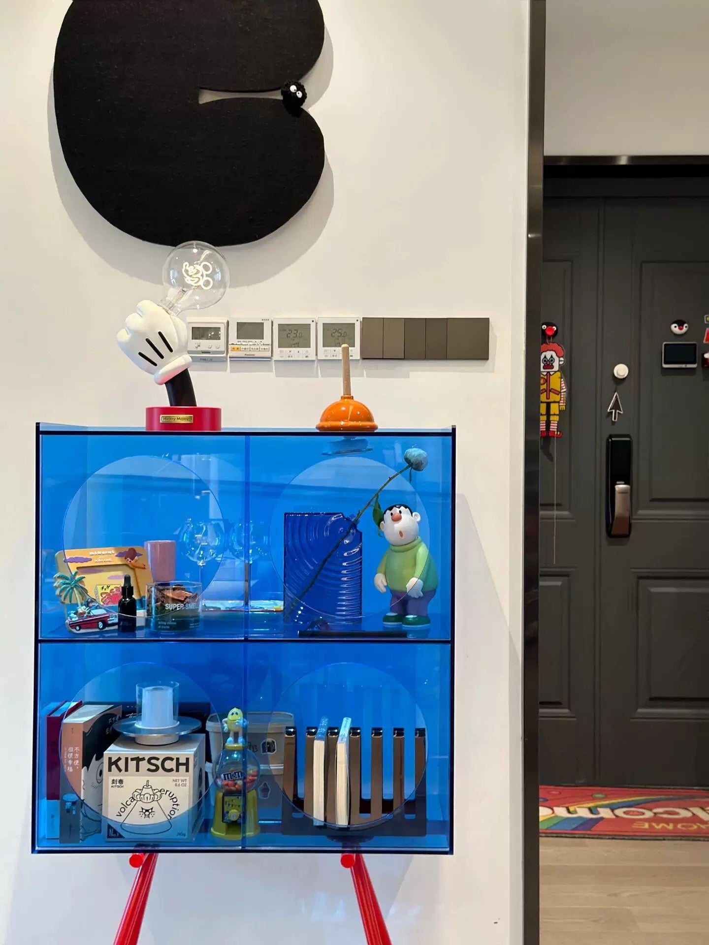 Modern acrylic display cabinet highlighting collectible toys in clean contemporary interior space