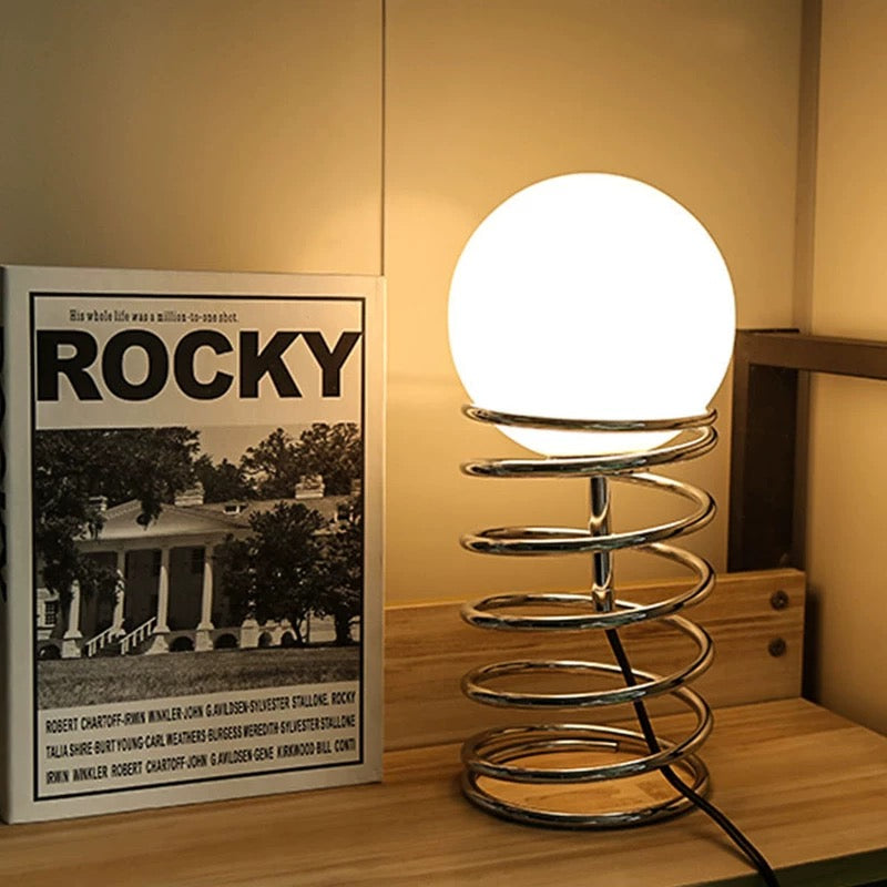 Side profile highlighting the stainless steel base and glass shade of the lamp