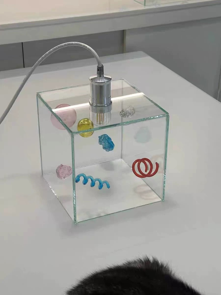 Clear container with colorful objects inside on a white surface