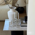 The candle holder placed on a modern dining table, adding a touch of elegance.