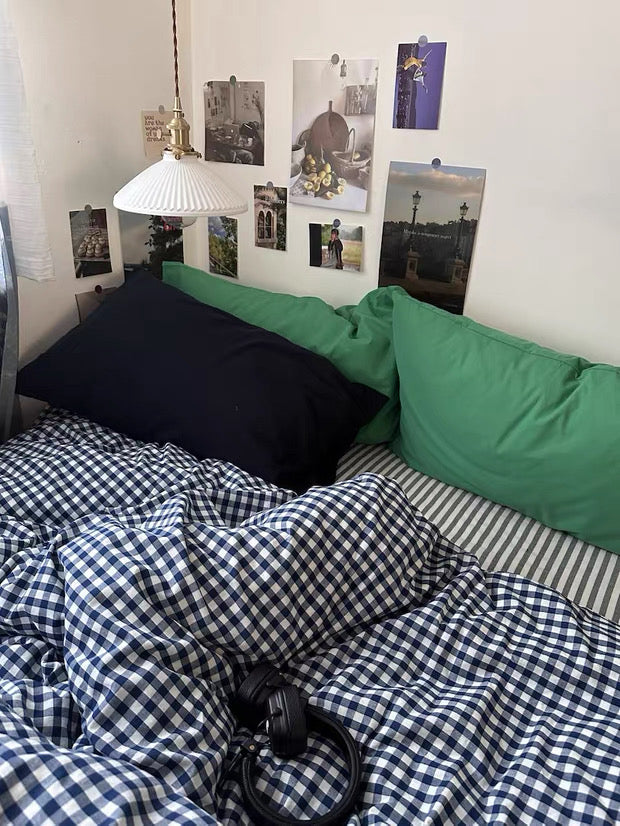 Navy checkered bedding set with wall prints, books, and vintage dorm room styling.