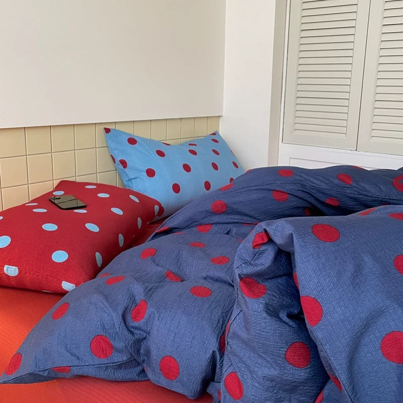 Blue and red polka dot duvet cover styled for playful teen bedroom decor cozy aesthetic