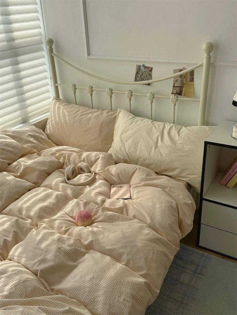 Neatly made bed with beige bedding in a well-lit room