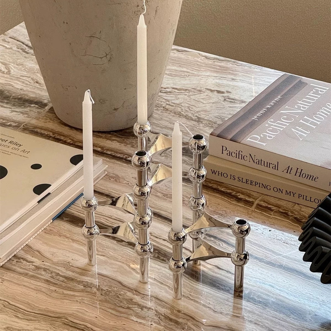 The candlestick on a mantelpiece, complementing minimalist décor.