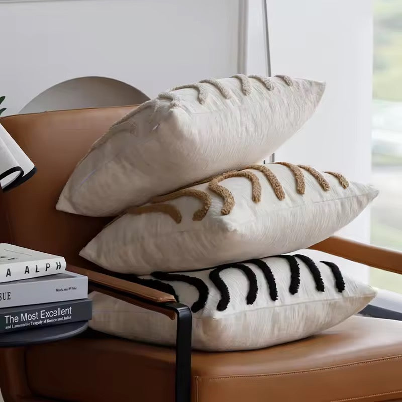 Decorative pillows with textured patterns on a brown chair.