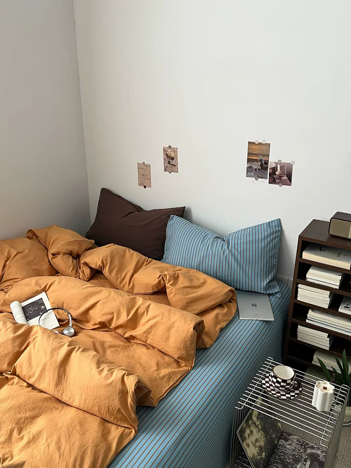 Angled view of the orange duvet cover and blue striped bedding in the room