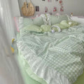 Close-up of lace ruffle edge on pastel pink gingham bedding set