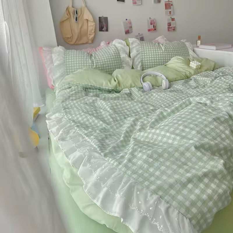 Close-up of lace ruffle edge on pastel pink gingham bedding set
