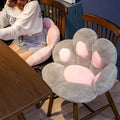 Chair with paw-shaped pink and gray cushions in a room setting.