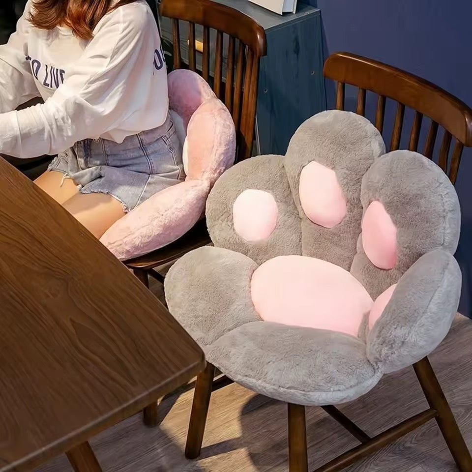 Chair with paw-shaped pink and gray cushions in a room setting.