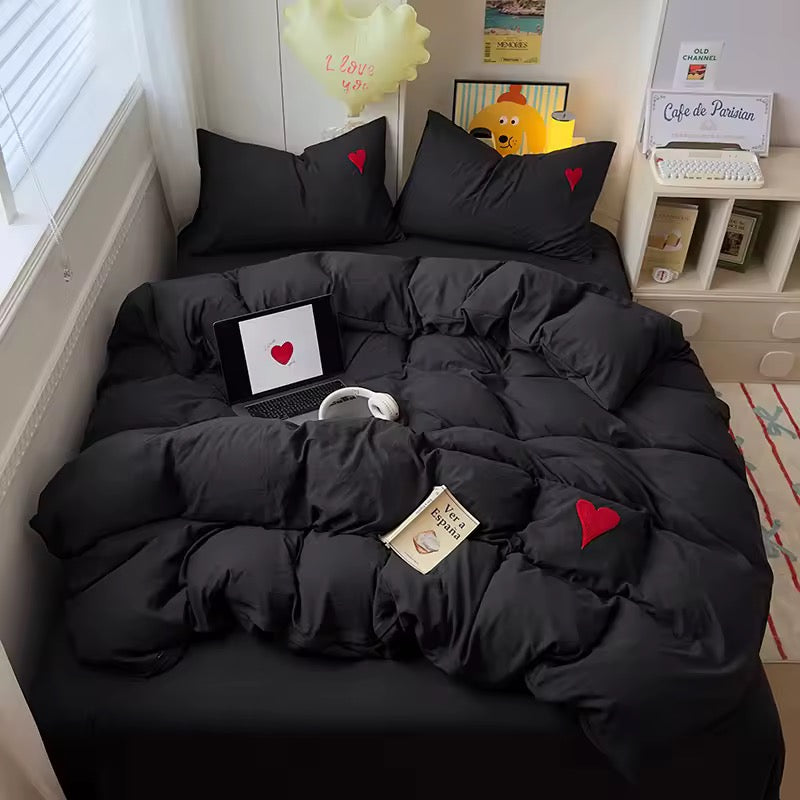 Flat lay of 4-piece bedding set including duvet cover, flat sheet, and pillowcases.