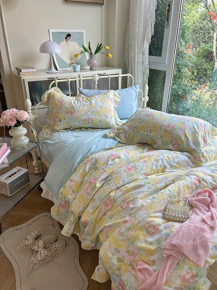 Pastel rose bedding with a light blue sheet in a cottagecore bedroom
