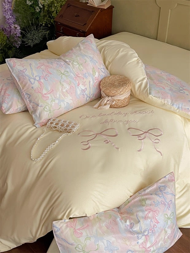 Decorative bedspread with embroidered text and floral patterns on a bed.