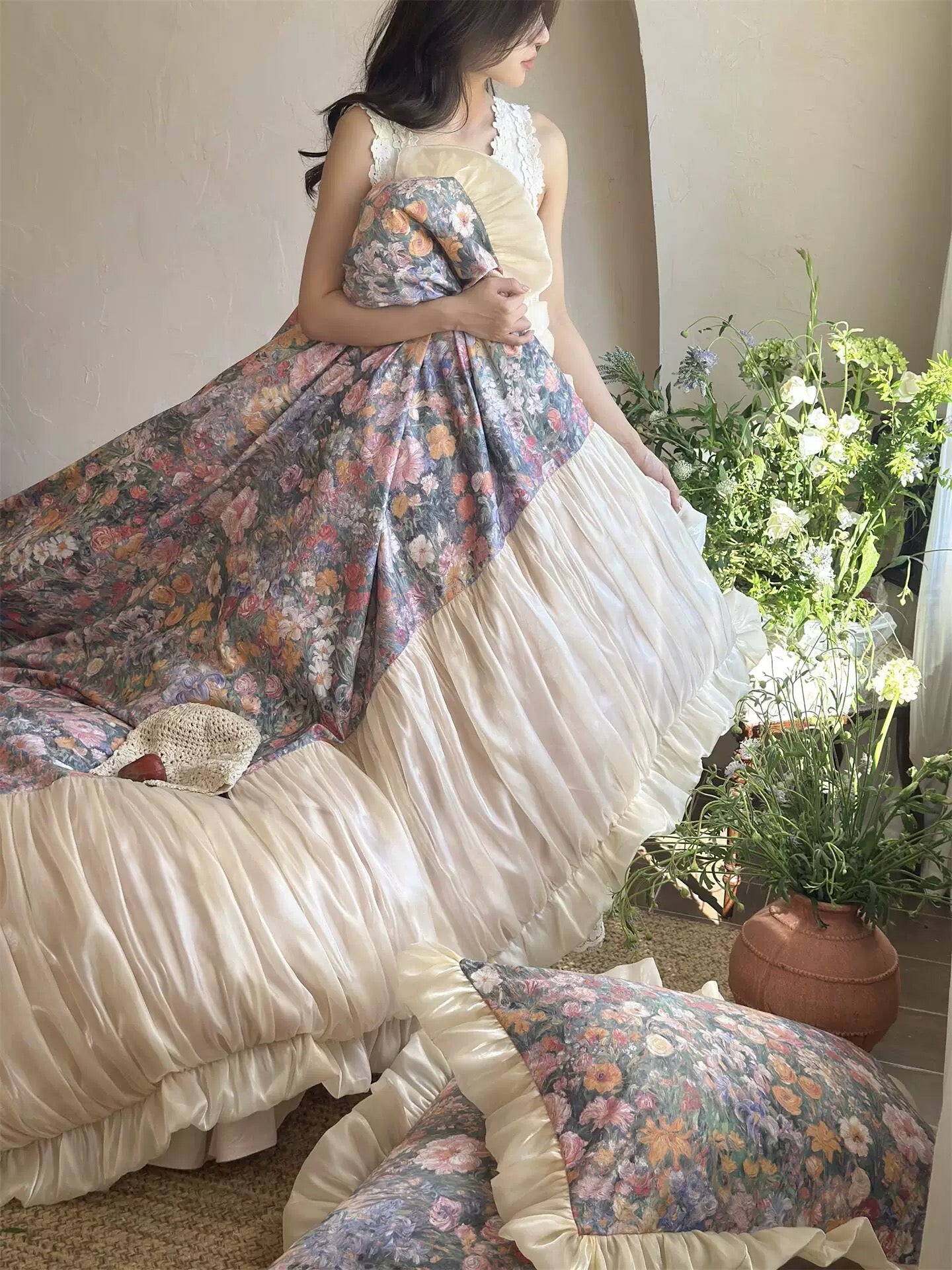 Woman in a floral dress standing in a room with plants and furniture.