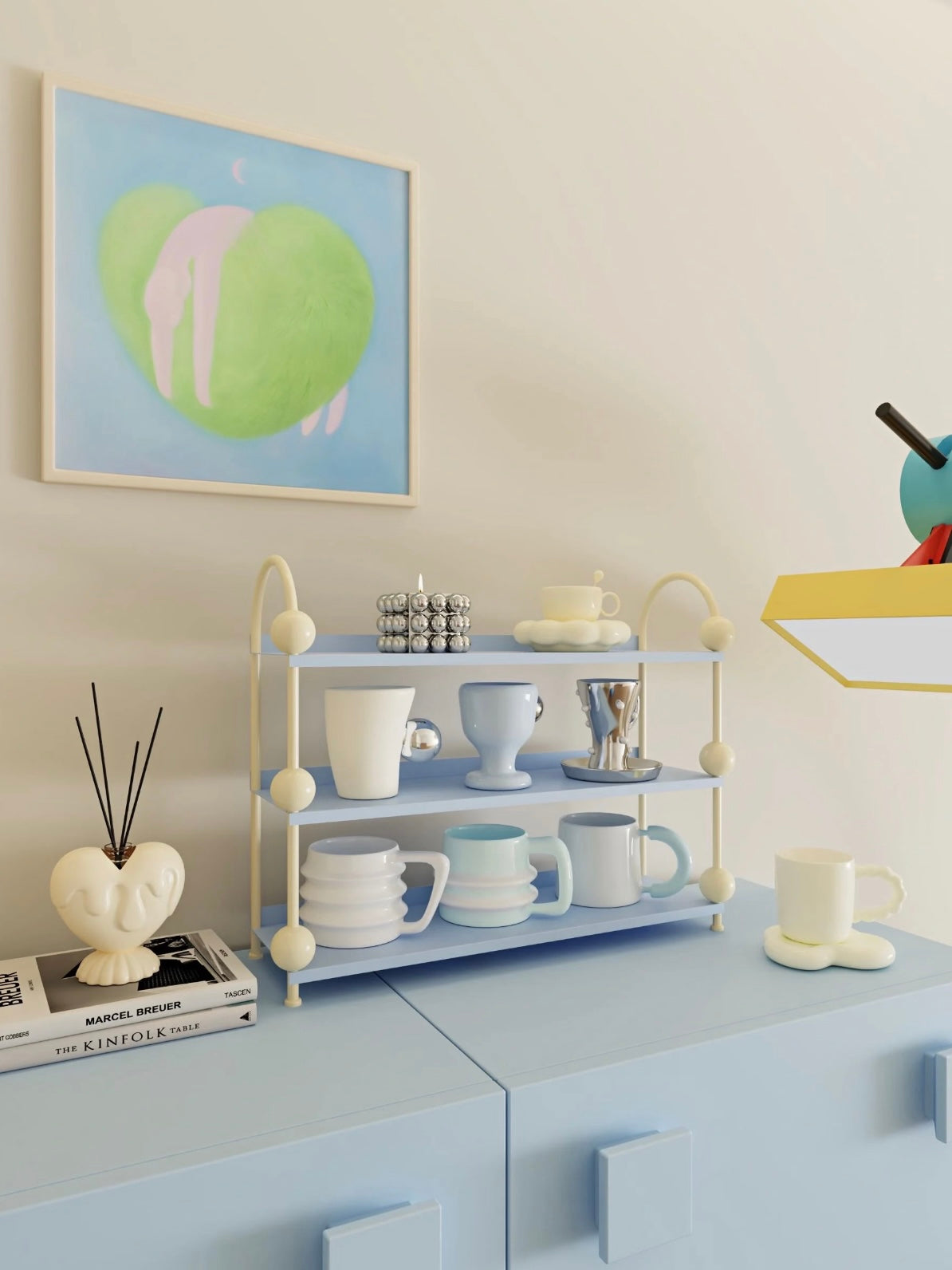 Blue perfume organizer shelf viewed from the side, with cups on open tiers between cream arched supports.