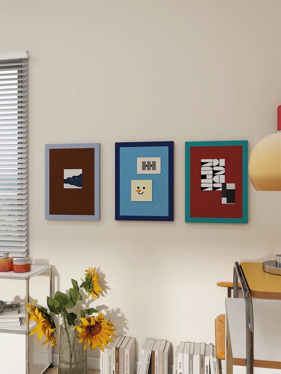 Three photo pin boards in contrasting colors above a console and lamp.