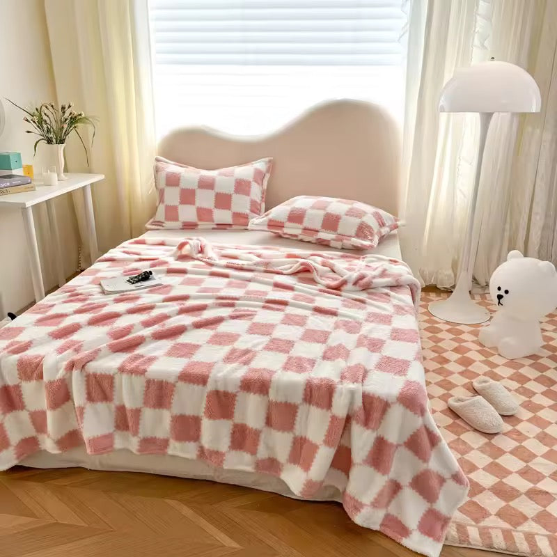 Person holding a pink and white checkered blanket in a cozy room.