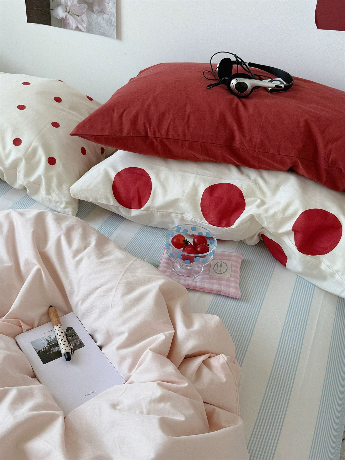 Close view of a red pillow over a large red dot pillowcase beside the pink duvet cover.