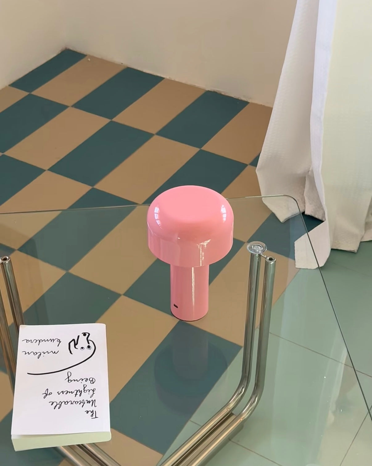 Pink object on a glass table with a checkered floor and white curtain in the backgroundslider_item_zjHr7Y