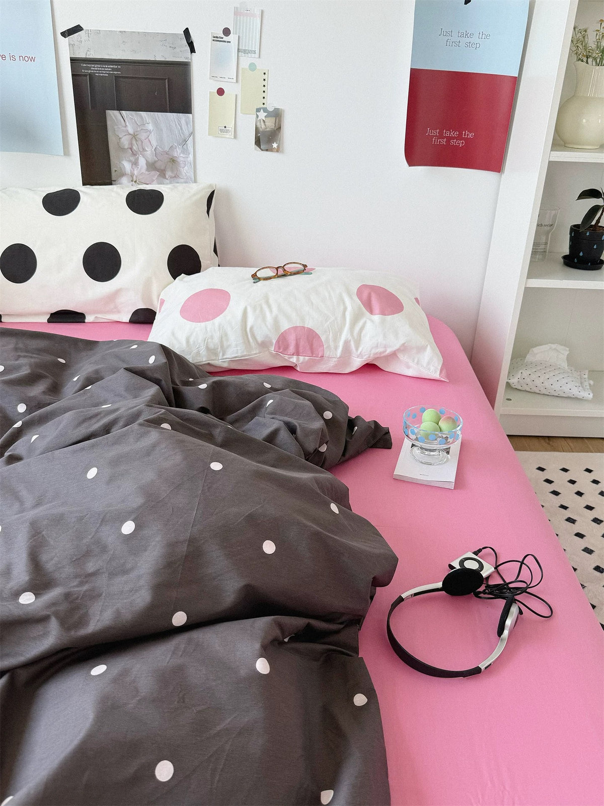 Pink and gray bedding with large black dots on one pillow and pink dots on the other.