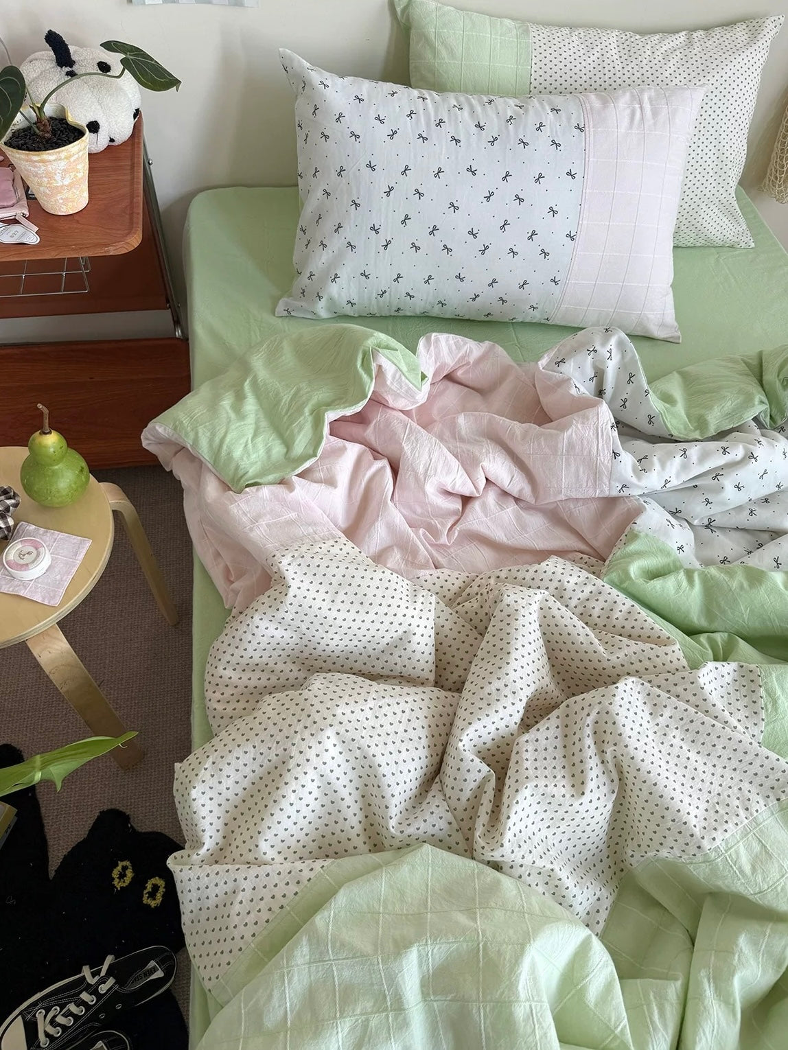 Pastel green and pink patchwork duvet cover set arranged on a bed