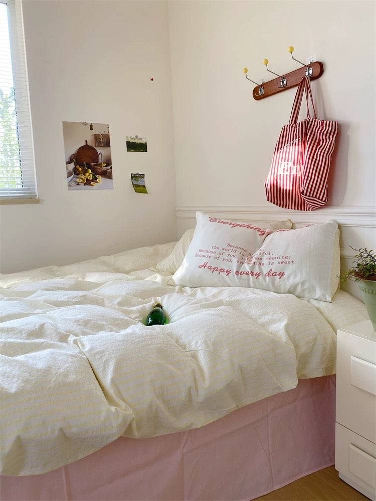 Bedroom with a bed, pillows, and a bag hanging on the wall.