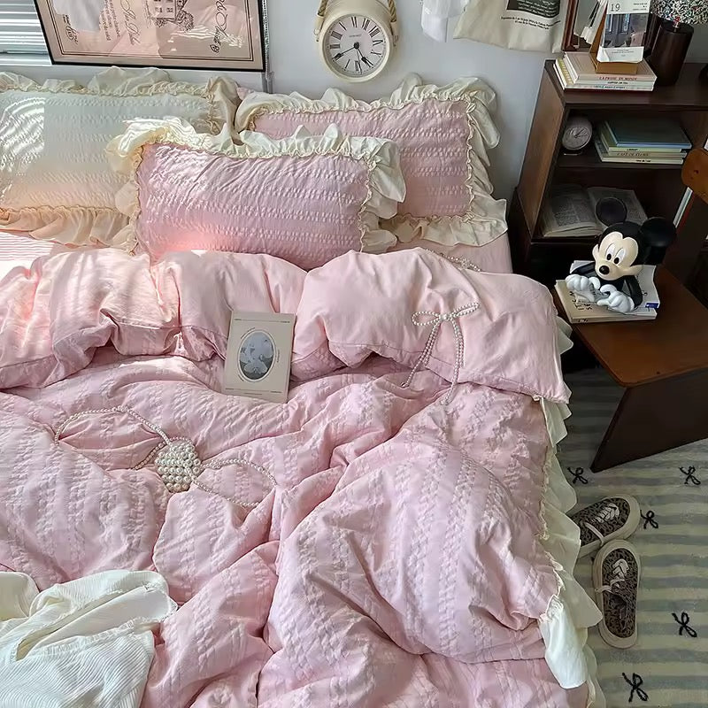 Pink ruffled Korean princess bedding set with cream lace trim on a cozy bed