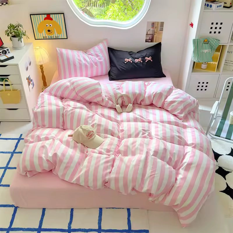 Pink striped cotton bedding set displayed on a neatly made bed in a pastel-themed room