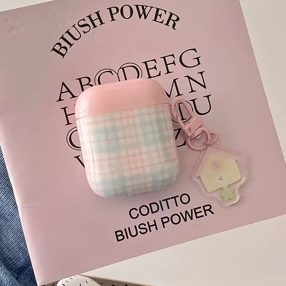 Pink and plaid airpod case with keychain on a pink 'CODITTO Blush Power' book