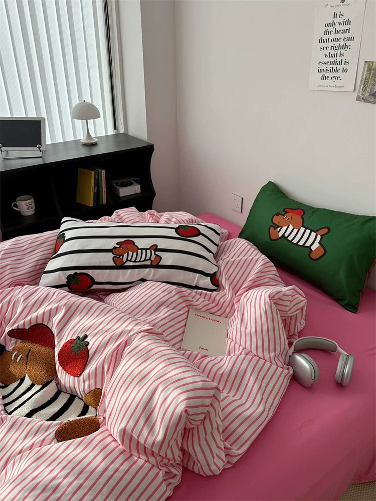 Bedroom with pink striped bedding and cartoon-themed pillows