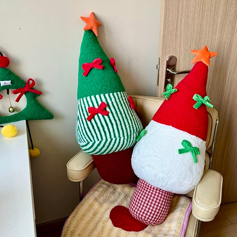 Red and green Christmas tree pillows beside seasonal room decor