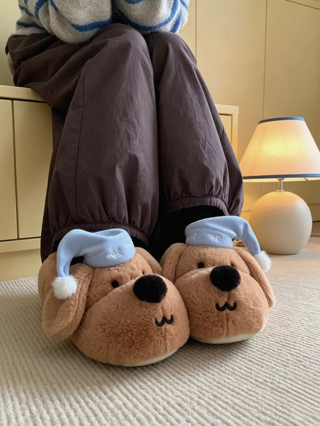 Brown plush dog slippers with blue sleeping caps worn indoors