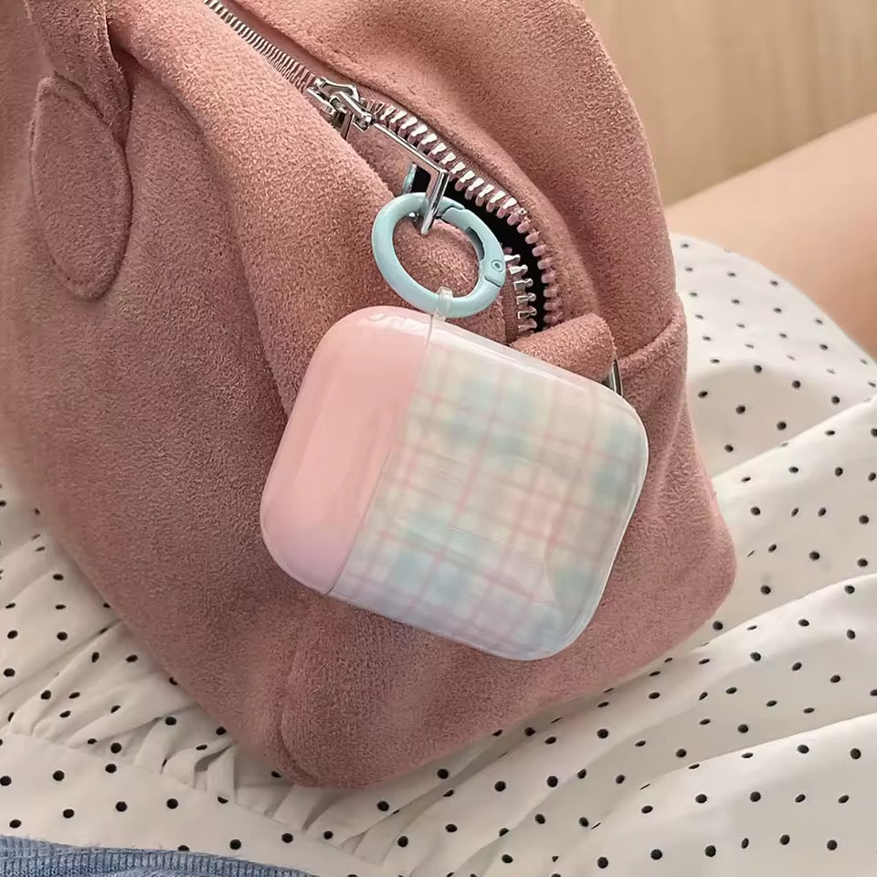 Pink textured pouch with a checkered air pod case hanging from a zipper.