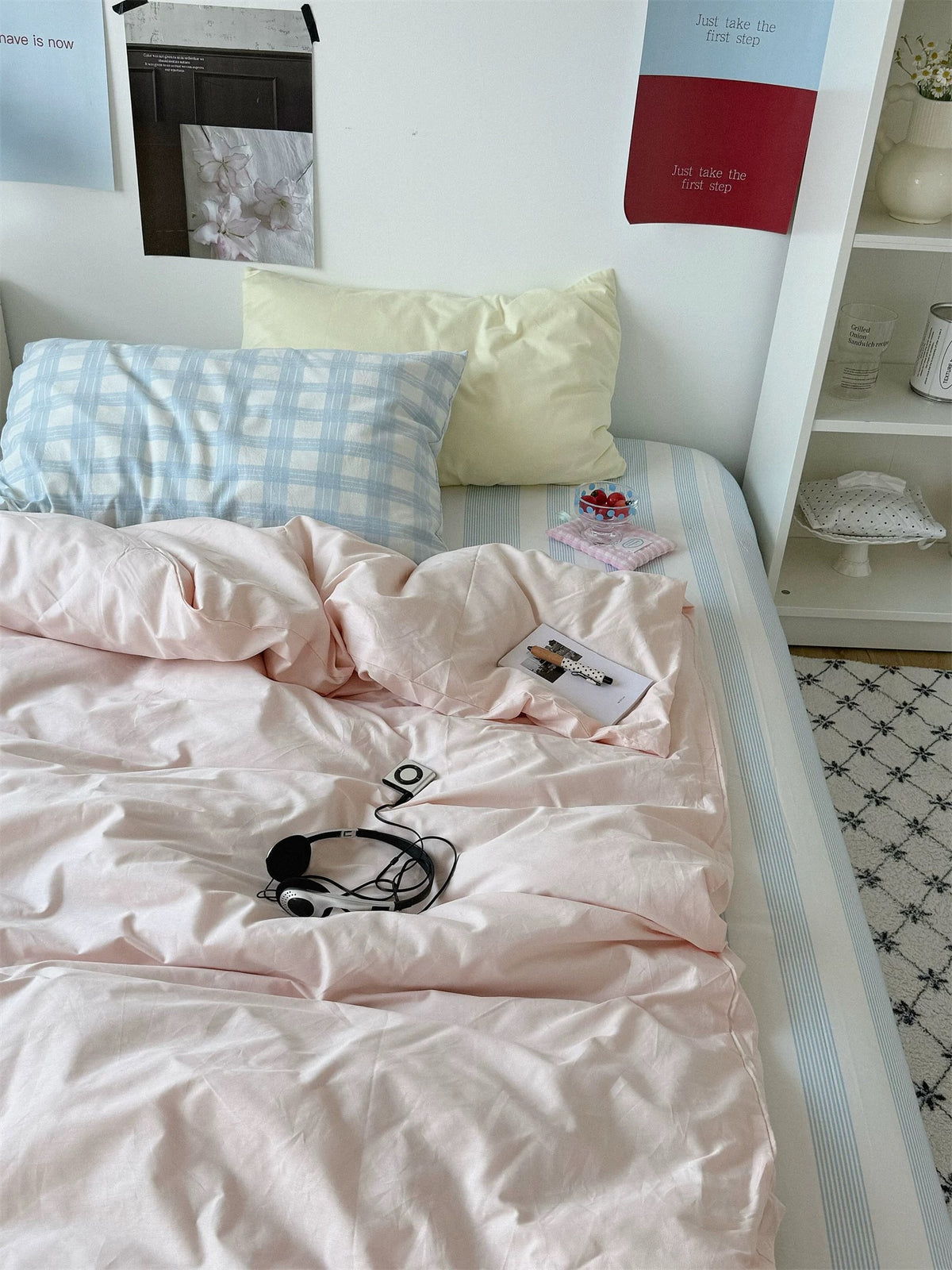 Preppy bedding with a pale yellow pillow, blue checked pillowcase and blue striped sheet.
