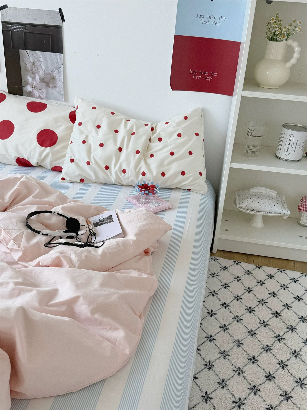 Preppy polka dot bedding with two sizes of red dots, a pale pink duvet cover and headphones.