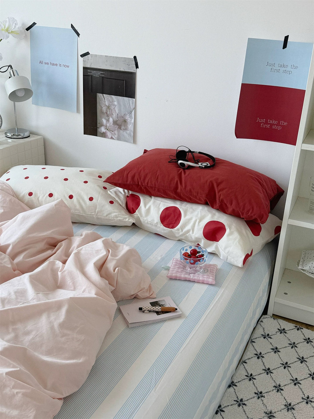 Preppy polka dot bedding set with a pink duvet cover, red and dotted pillows, and a blue striped sheet.