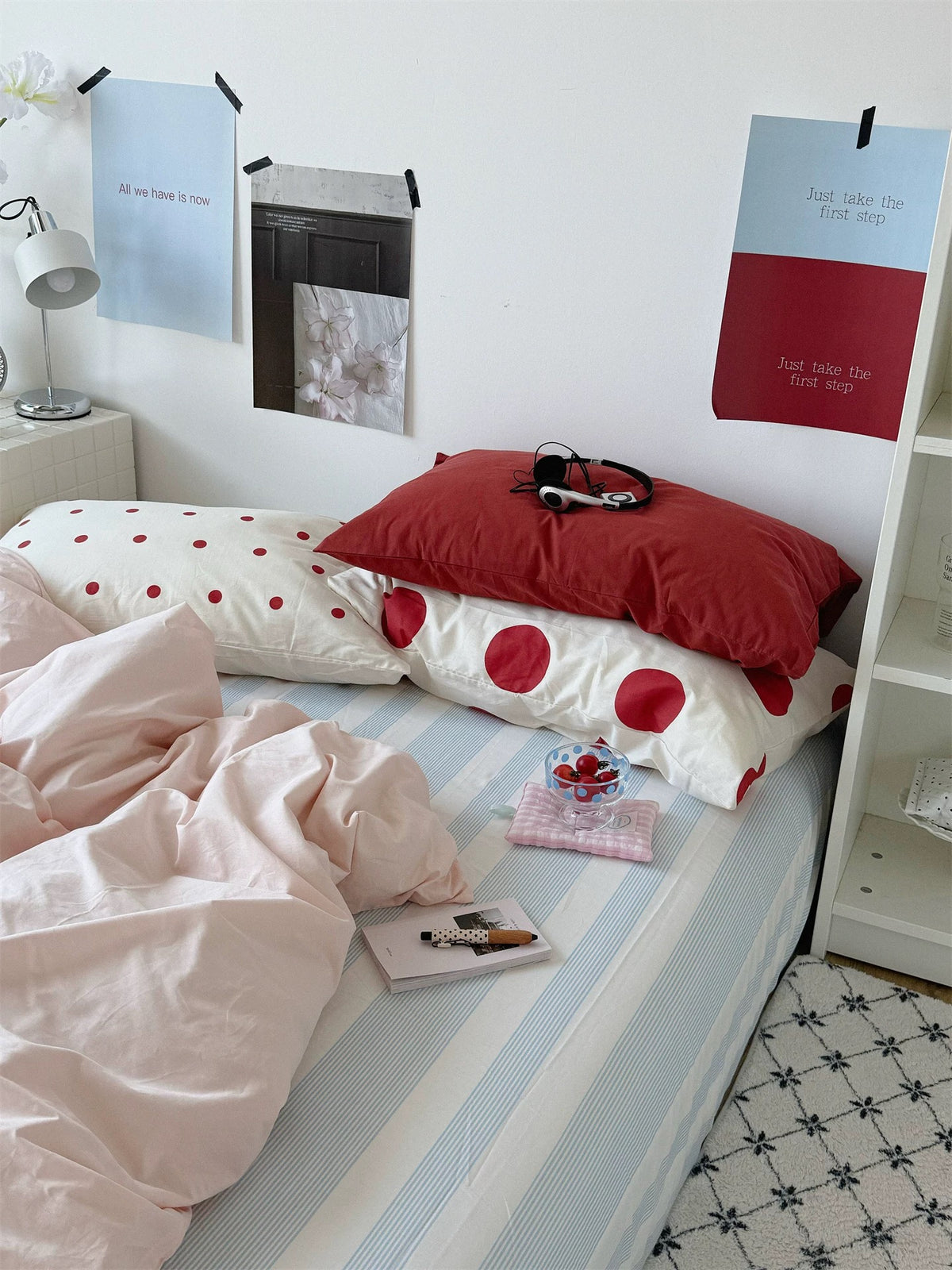 Preppy polka dot bedding set with a pink duvet cover, red and dotted pillows, and a blue striped sheet.
