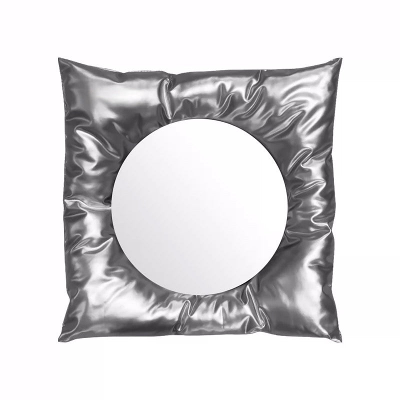 Silver metallic pillow with a round cutout on a white background