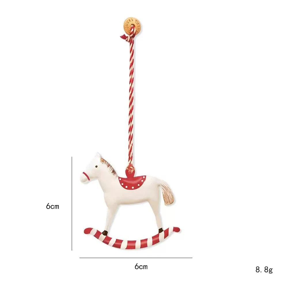 A red rocking horse Christmas ornament has a white horse, dotted red saddle and striped curved rocker.