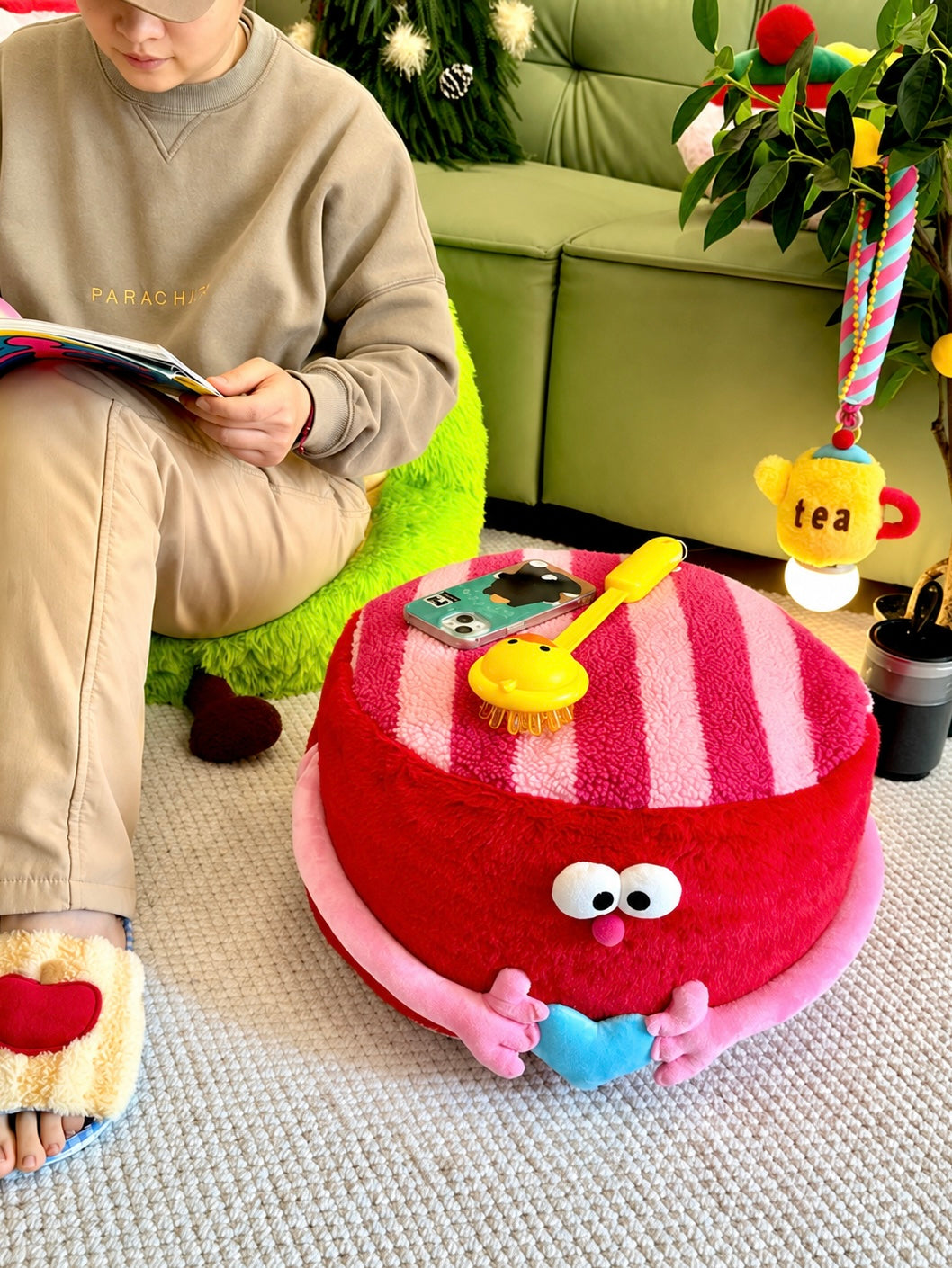 Red round footstool pouf held beside colorful bedroom decor