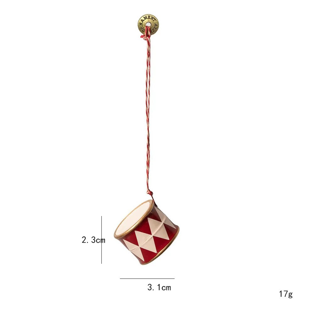 A red and white drum Christmas ornament has a diamond pattern around the sides and gold colored rims.