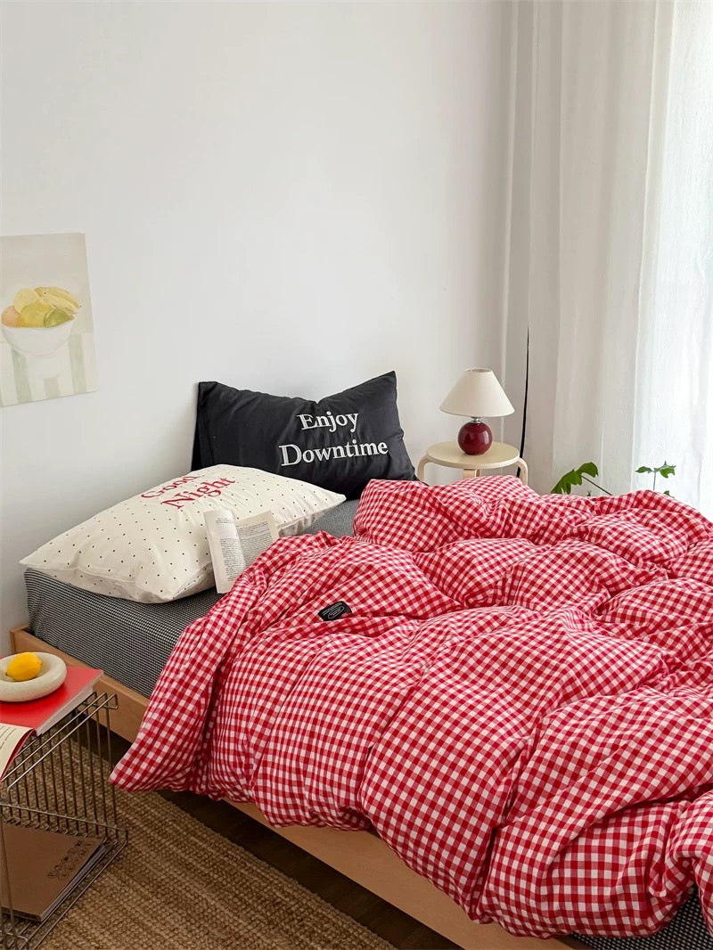 Red and white checkered duvet on a bed with decorative pillows in a bedroom setting.