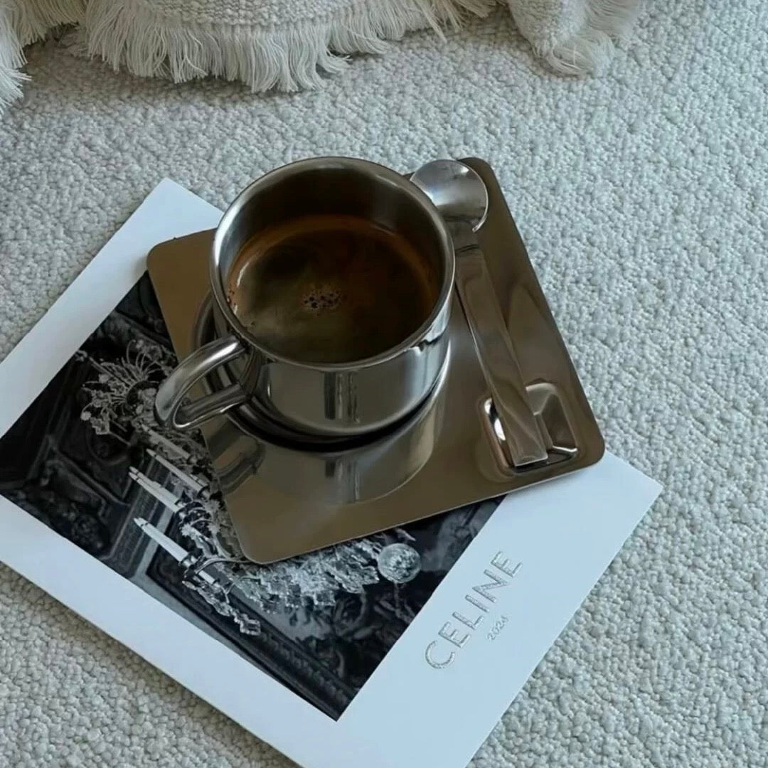 Metallic cup and saucer on a magazine with 'CELINE' branding