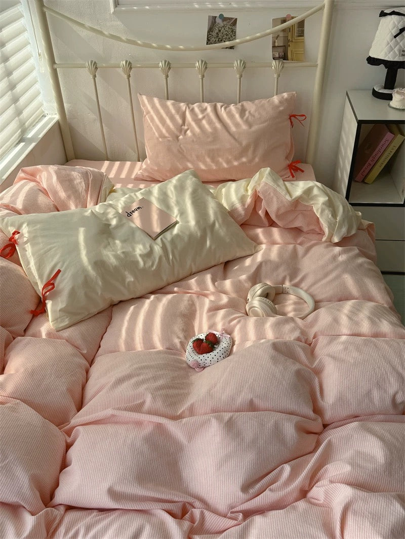 Pink bedroom with a neatly made bed and nightstand.