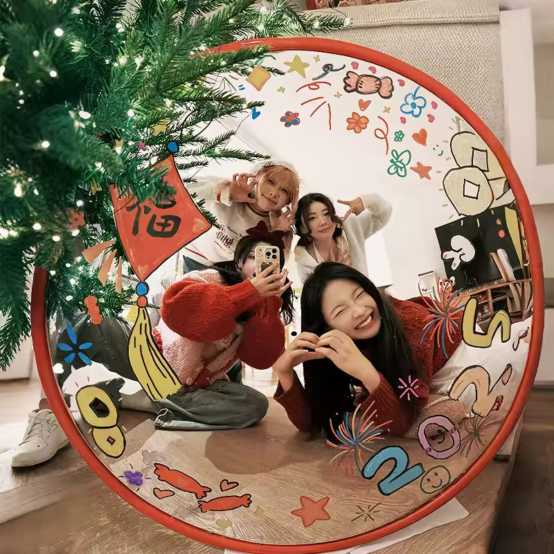 Four people posing in front of a decorated Christmas tree with a colorful circular frame.