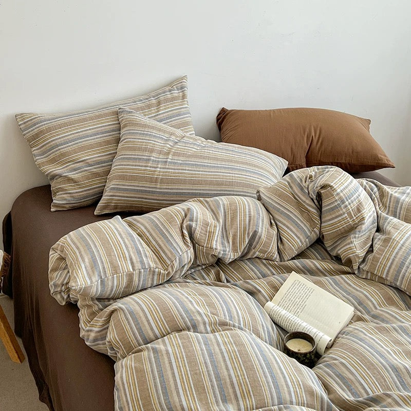 Sandstone striped bedding set with warm neutral palette creating inviting contemporary bedroom interior design.