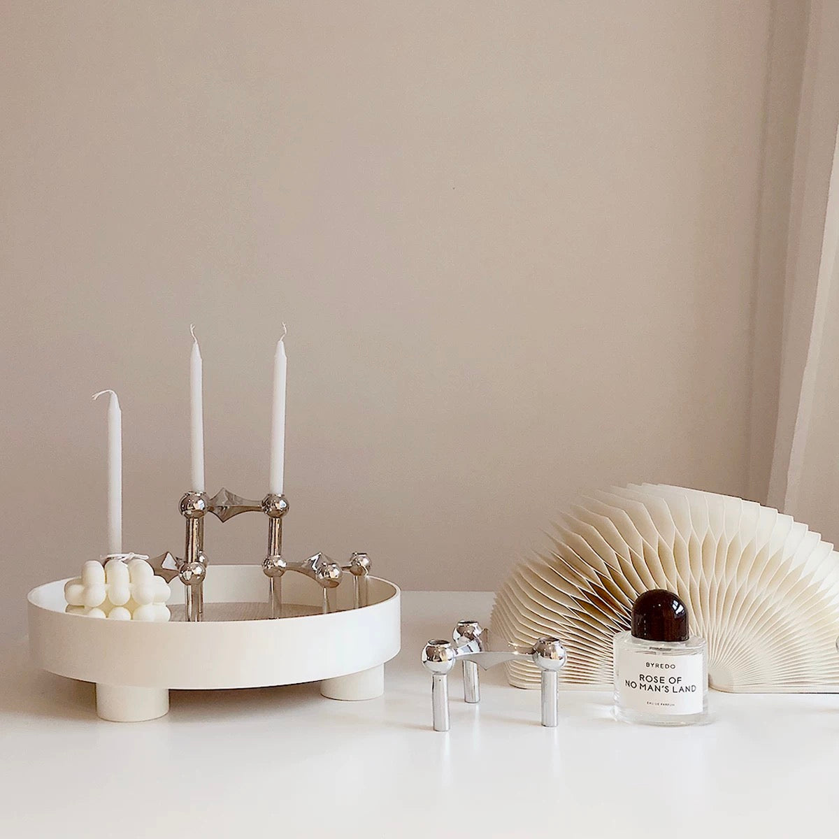 The candle holder paired with other Nordic décor items on a shelf.