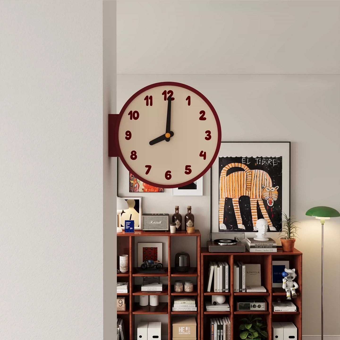 Wall clock on a shelf with decorative items against a light gray wall