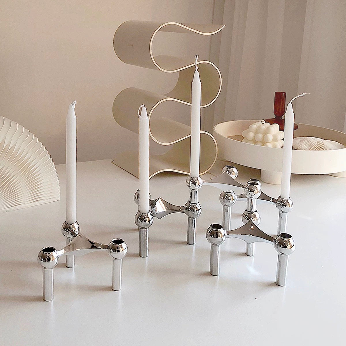 The candle holder used as a centerpiece in a wedding table setting.