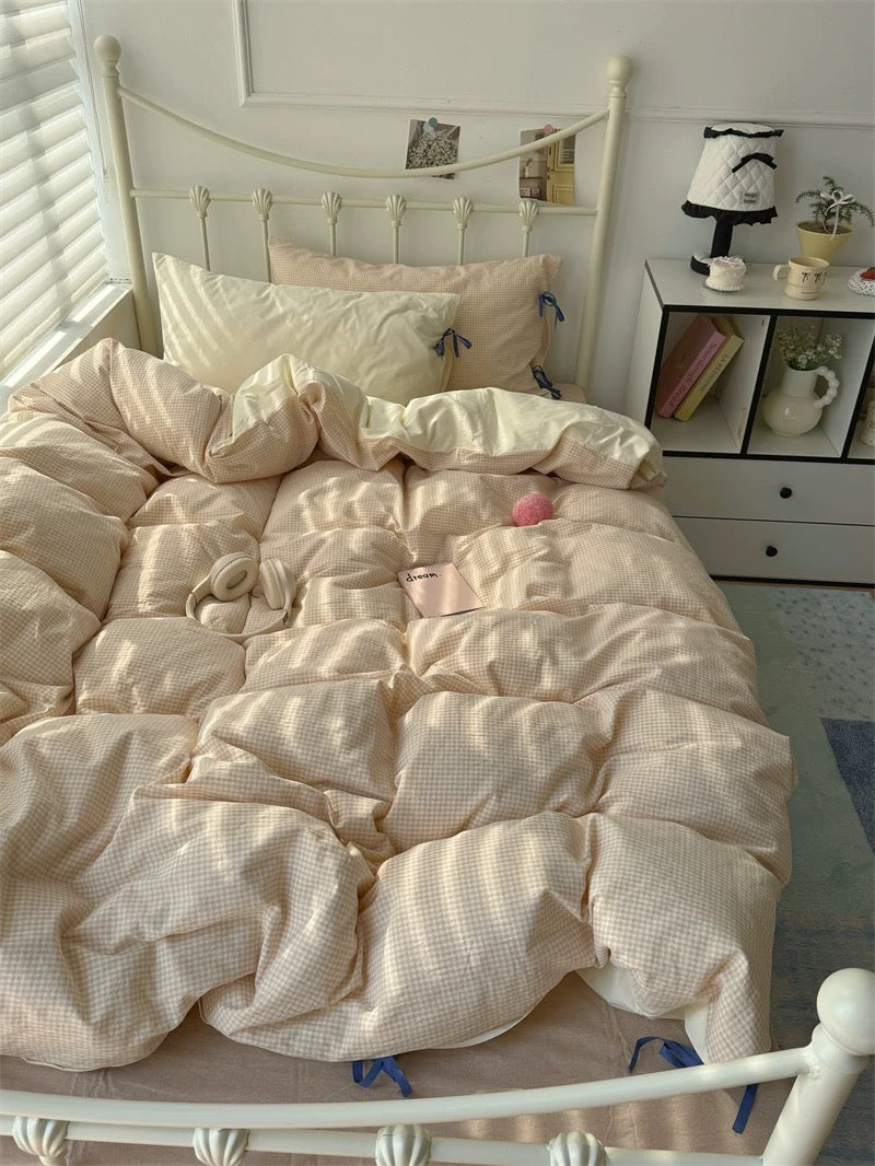 Neatly made bed with beige bedding in a well-lit bedroom.